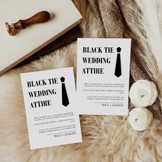 two black and white wedding stationery cards on fur