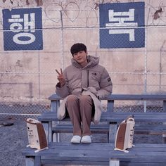 a man sitting on top of a wooden bench