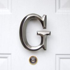 the letter g is attached to a white door