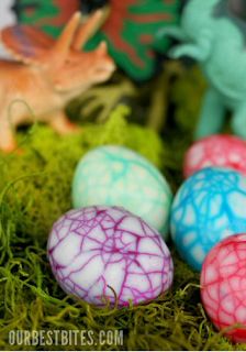 small plastic dinosaur eggs sitting on moss