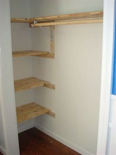 an empty closet with wooden shelves in it