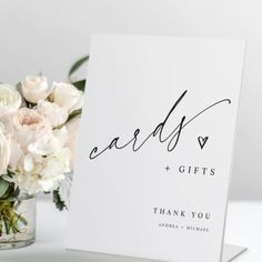 a white card with the words cards and gifts written on it next to a bouquet of flowers