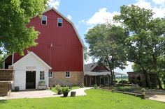 a red barn sitting next to a lush green field