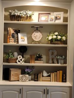 an open bookcase with flowers and books on it