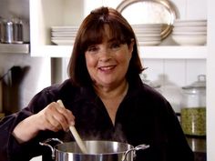 a woman stirring a pot with a wooden spoon