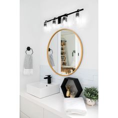 a bathroom with a round mirror above the sink and lights on the wall next to it