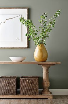 a table with two baskets and a vase on it