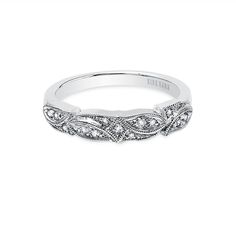 a white gold wedding band with diamonds on the sides and an intricate design in the middle