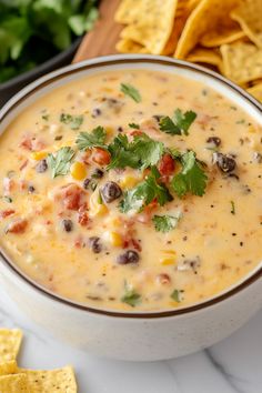 a white bowl filled with black bean and corn salsa next to tortilla chips