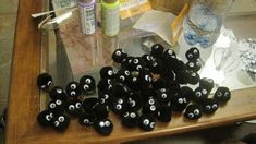 several black and white stuffed animals on a table with water bottles, scissors and other crafting supplies