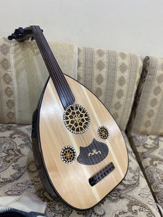 a wooden guitar sitting on top of a couch