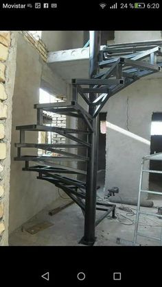 a metal spiral staircase in an unfinished building