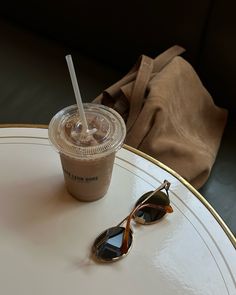 a cup of coffee and sunglasses on a table