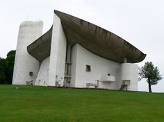 an unusual building sits on top of a grassy hill