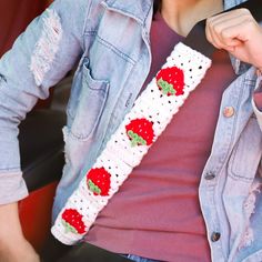 a woman is wearing a crocheted strawberry belt