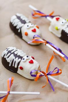 halloween candy pops decorated like skeletons and bones with colorful streamers on the top one