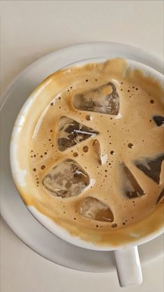 a cup of coffee with ice cubes in it