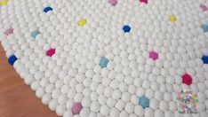 a white rug with multicolored balls on it