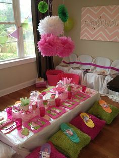 a table set up for a birthday party with pink and green decorations on the tables