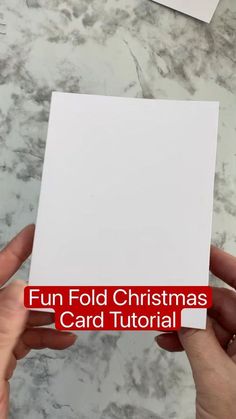 someone holding up a white card with the words fun fold christmas card tutorial on it