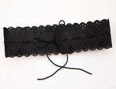 Black leather women's belt with unique design- it has beautiful lace pattern all around from different size holes. We make this pattern punching each hole with different size punchers. This magnificent belt will accentuate your style be it casual or bizarre. The belt is tied with a decorative black twine at the front or the back. We can make this belt in 3-5 business days. Main color: black Material: Genuine leather Black twine Wide- 11 cm (4.3 inch) Waist circumference: 1. Waist 23.6 - 27.6 inc Adjustable Black Embroidered Belt, Black Embroidered Adjustable Belt, Black Belt With Removable Feature For Festivals, Black Leather Belts For Festivals, Black Leather Festival Belts, Black Embroidered Belt For Party, Party Black Embroidered Belt, Waist Corset Belt, Lace Belt