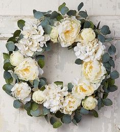 a wreath with white flowers and green leaves