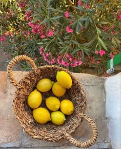 a basket filled with lemons sitting on top of a stone wall