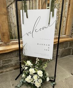 a welcome sign sitting next to a bouquet of flowers