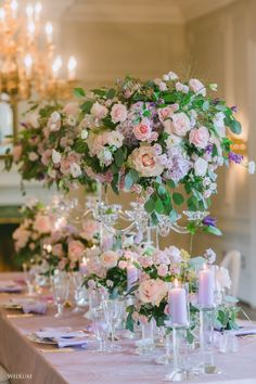 the table is set with candles, flowers and wine glasses for an elegant wedding reception