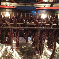 several racks of meat hang from the ceiling