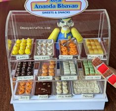 an assortment of sweets and snacks displayed in a display case on a wooden table top