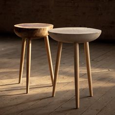 two wooden stools sitting on top of a hard wood floor next to each other