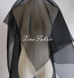 the back of a woman's dress with sheer black and grey fabric on it