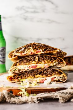 three sandwiches stacked on top of each other with the text crunchwrap supreme in the middle