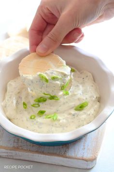 a person dipping some kind of food into a bowl