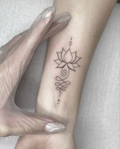 a woman's arm with a tattoo that has a flower on it and an arrow