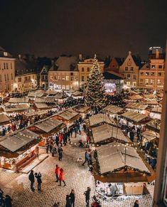 an aerial view of a christmas market in the middle of town with lots of people walking around