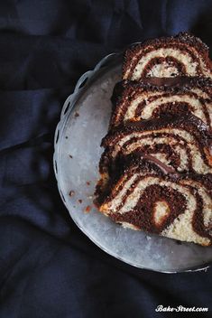 there is a piece of cake on the plate and it has chocolate icing that looks like swirls