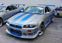 two cars parked next to each other in a parking lot with blue and white stripes on them