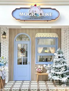 a store front with a christmas tree in the foreground and two blue doors on either side