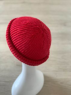 a red knitted hat on a white mannequin head