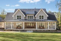 a large house with lots of windows on the front and side of it, surrounded by grass