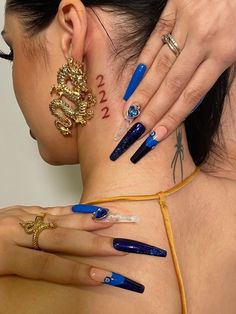 a woman with blue nail polish on her neck and shoulder, holding onto the back of her neck