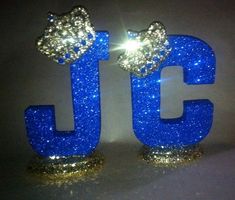 two blue glittered letters with bows on them