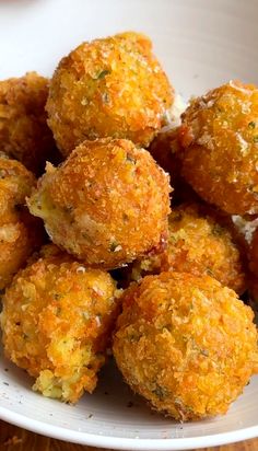 a white bowl filled with fried food on top of a wooden table