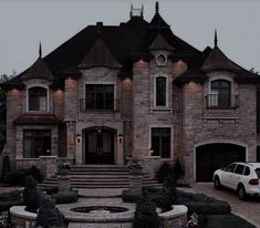 a white car parked in front of a large brick house with stone steps leading up to it's entrance