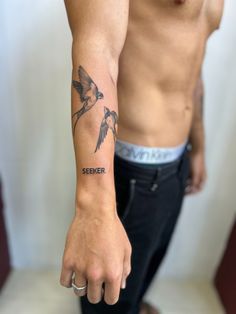 a man with a bird tattoo on his arm