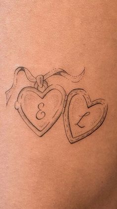 a woman's stomach with two heart shaped tattoos on it