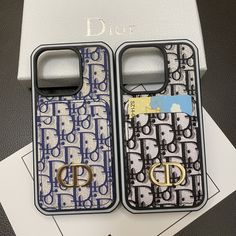 two cell phones are sitting next to each other on top of a card holder with the word dior printed on it