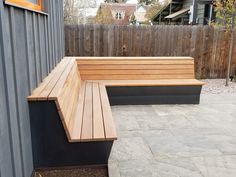 a wooden bench sitting next to a building